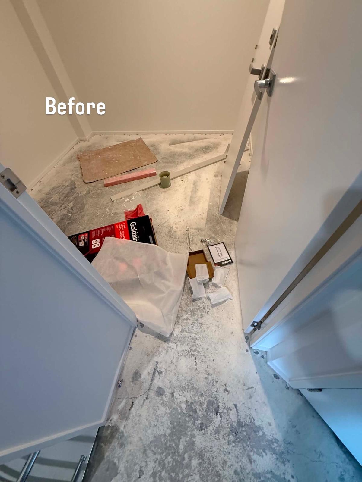 Cupboard floor with worn carpet lifted, showing the bare boards underneath